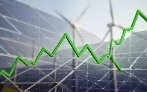Ein fallender grüner Börsenchart vor einem unscharfen Hintergrund von Solarpaneelen oder Windturbinen, der den Rückgang von Clean Energy Aktien symbolisiert. - Foto: über boerse-global.de