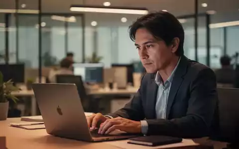 Eine Person sitzt nachdenklich an einem Schreibtisch vor einem Laptop, während im Hintergrund ein modernes Büro verschwommen zu sehen ist. - Foto: über boerse-global.de