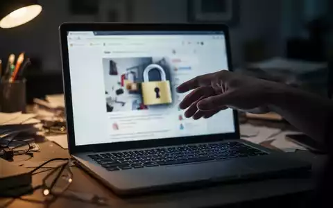 Eine Hand schwebt über einer Laptoptastatur, der Bildschirm zeigt eine verschwommene, betrügerische Online-Shop-Oberfläche. - Foto: über boerse-global.de
