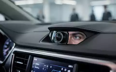 Nahaufnahme einer Armatur mit einer integrierten Kamera, die subtil ein Auge des Fahrers reflektiert, symbolisiert Überwachung am Arbeitsplatz. - Foto: über boerse-global.de