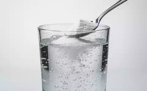 Ein Glas mit sprudelndem Wasser und einem Löffel Backpulver, das die fehlende wissenschaftliche Grundlage von Gesundheitstrends symbolisiert. - Foto: über boerse-global.de