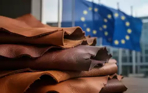 Ein Stapel luxuriöser, texturierter Lederhäute in warmen Erdtönen, im Hintergrund verschwommen ein EU-Gebäude. - Foto: über boerse-global.de