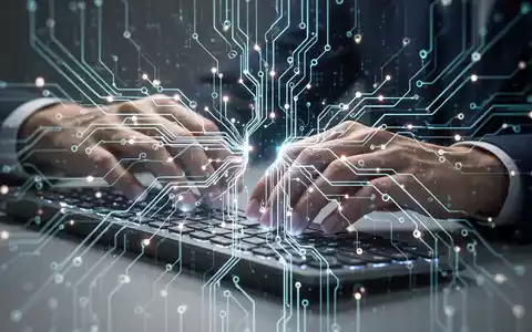 Eine Nahaufnahme einer Hand, die auf einer Tastatur tippt, mit einer leuchtenden, stilisierten Darstellung eines neuronalen Netzwerks darüber. - Foto: über boerse-global.de
