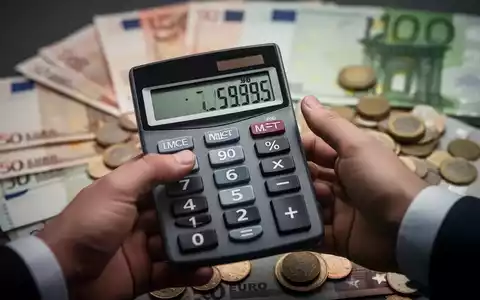 Eine Hand hält einen Taschenrechner, der negative Zahlen anzeigt, mit verschwommenen Euro-Banknoten und Münzen im Hintergrund. - Foto: über boerse-global.de