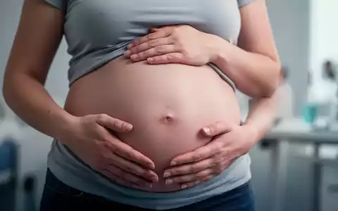 Hände einer Frau ruhen auf ihrem deutlich geschwollenen Bauch, der das Symptom des 'Endo-Belly' bei Endometriose darstellt. - Foto: über boerse-global.de