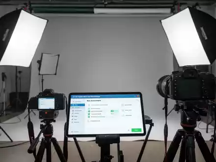 Ein modernes Fotostudio mit Beleuchtung und Kameras. Ein Tablet zeigt eine Software zur Gefährdungsbeurteilung. Fokus auf Sicherheit und digitale Tools. - Foto: über boerse-global.de