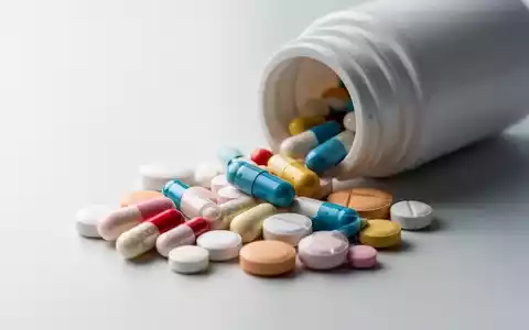 Nahaufnahme von verschiedenen pharmazeutischen Pillen und Kapseln, die aus einer Flasche auf einer Oberfläche liegen. - Foto: über boerse-global.de