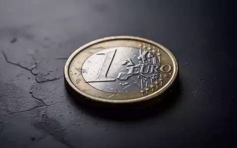 Eine einzelne, abgenutzte Euro-Münze liegt auf einer dunklen, strukturierten Oberfläche, symbolisch für Sparmaßnahmen und soziale Kürzungen. - Foto: über boerse-global.de