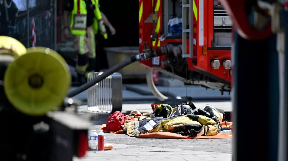Rettungskräfte bringen mindestens zwei Menschen nach dem Brand mit Verbrennungen in ein Krankenhaus.  - Bild: Emile Windal/Belga/dpa