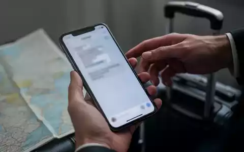 Eine Hand hält ein Smartphone, während eine andere Hand im Hintergrund danach greift, was Diebstahl und Betrug symbolisiert. - Foto: über boerse-global.de