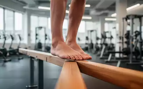 Nahaufnahme von Füßen, die auf einem Holzbalken balancieren, im Hintergrund ein Fitnessstudio. - Foto: über boerse-global.de