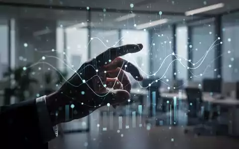 Eine stilisierte menschliche Hand interagiert mit einem holografischen Interface, das abstrakte Datenpunkte und Linien anzeigt. - Foto: über boerse-global.de