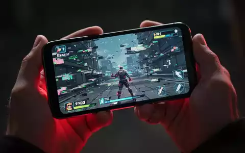 Nahaufnahme von Händen, die ein Smartphone mit einem ruckelnden Handyspiel halten, symbolisiert Leistungsprobleme. - Foto: über boerse-global.de