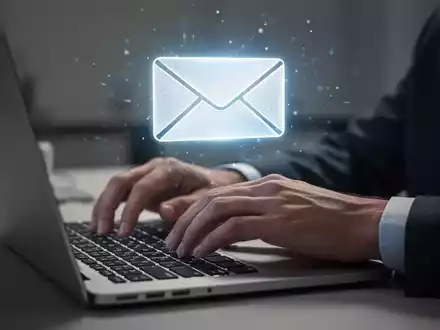 Hände tippen auf Laptop-Tastatur, leuchtendes E-Mail-Symbol schwebt über dem Bildschirm. - Foto: über boerse-global.de