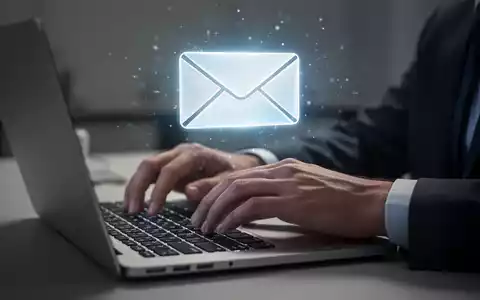 Hände tippen auf Laptop-Tastatur, leuchtendes E-Mail-Symbol schwebt über dem Bildschirm. - Foto: über boerse-global.de