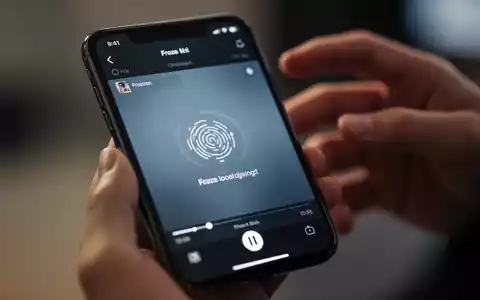 Nahaufnahme eines iPhone-Bildschirms mit eingefrorenem Video und unscharfen Händen im Hintergrund, symbolisiert Wiedergabeprobleme. - Foto: über boerse-global.de