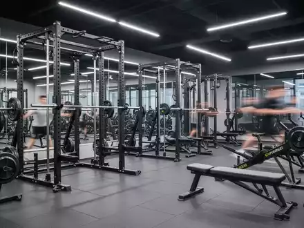 Eine moderne, hochtechnologische Kraftkammer mit Power Racks, Ergometern und Hantelbänken, bereit für junge Leistungssportler. - Foto: über boerse-global.de