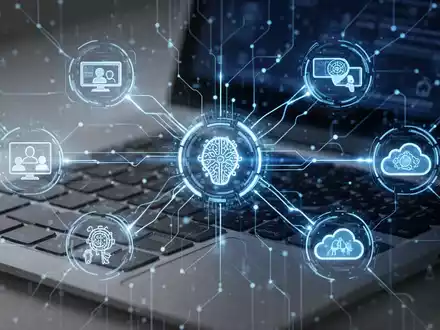 Leuchtend blaues digitales Netzwerk verbindet Symbole für Videokonferenz, KI und Cloud-Computing über einer Laptop-Tastatur. - Foto: über boerse-global.de