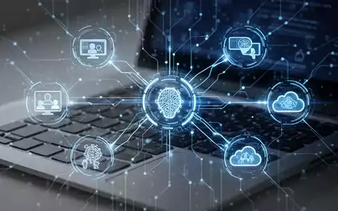 Leuchtend blaues digitales Netzwerk verbindet Symbole für Videokonferenz, KI und Cloud-Computing über einer Laptop-Tastatur. - Foto: über boerse-global.de