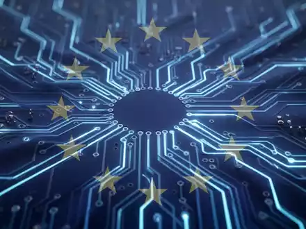 Stilisierte Leiterplatte mit leuchtend blauen Linien und durchscheinenden EU-Flaggensternen, die KI-Regulierung und verlängerte Fristen darstellt. - Foto: über boerse-global.de