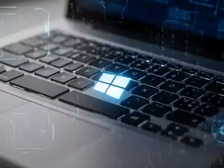 Nahaufnahme einer Laptop-Tastatur mit leuchtender Windows-Taste, die ein pausiertes Software-Update symbolisiert. - Foto: über boerse-global.de