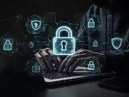 Schattenhafte Hände tippen auf einem Laptop, mit digitalen Schloss-Symbolen, die den Anstieg von Online-Betrug und Cyberkriminalität symbolisieren. - Foto: über boerse-global.de