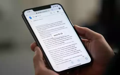 Ein Smartphone-Bildschirm zeigt ein Google Docs-Dokument mit sichtbarer Wortanzahl, gehalten in einer Hand. - Foto: über boerse-global.de
