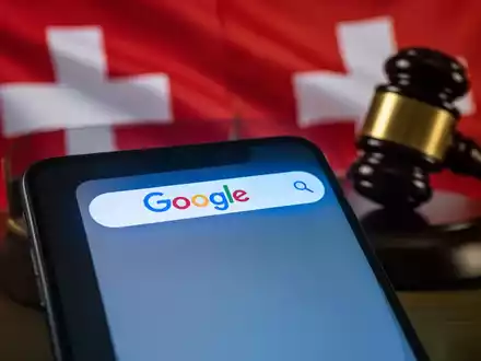 Smartphone-Bildschirm mit Google-Suchleiste, überlagert von verschwommener Schweizer Flagge und Richterhammer. - Foto: über boerse-global.de