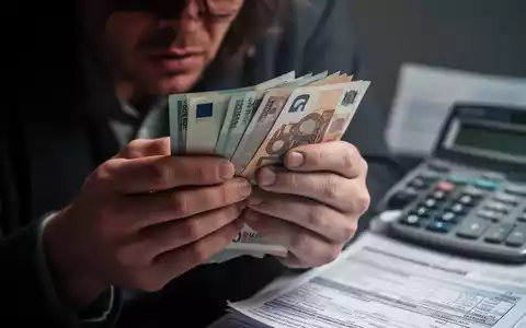 Nahaufnahme von Händen, die nervös Euro-Banknoten halten, im Hintergrund leicht verschwommen eine Rechnung. Symbolisiert finanzielle Sorgen. - Foto: über boerse-global.de