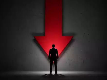 Eine Silhouette steht vor einem großen, roten Abwärtspfeil, der Schock und Besorgnis symbolisiert. - Foto: über boerse-global.de