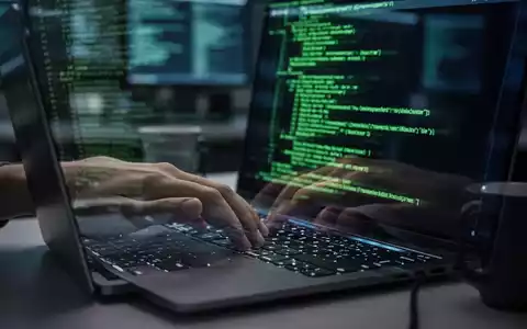 Hände tippen auf einer Laptop-Tastatur, grüne Befehlszeile leuchtet auf dem Bildschirm. - Foto: über boerse-global.de