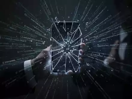 Eine schattige Hand hält ein glühendes, fragmentiertes Smartphone mit strahlendem Code, das ein durchgesickertes Regierungs-iPhone-Hacking-Toolkit symbolisiert. - Foto: über boerse-global.de