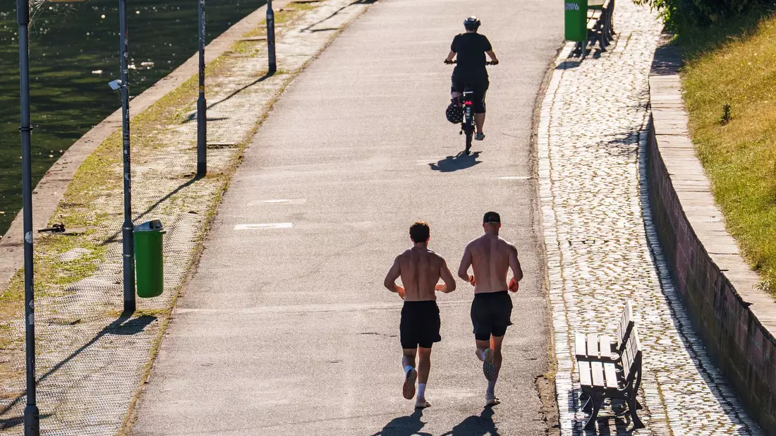 Zeigefreudige Männer mit nacktem Oberkörper und kurzer Hose beim Joggen. (Archivbild) - Bild: Andreas Arnold/dpa