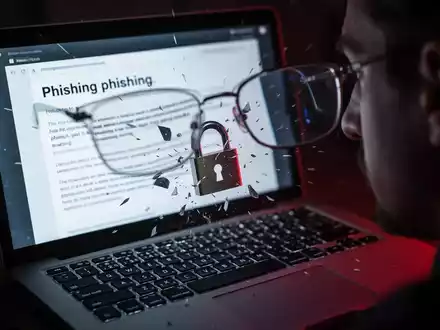 Nahaufnahme eines Laptop-Bildschirms mit Phishing-E-Mail, zerbrechendes Vorhängeschloss-Symbol symbolisiert Datenleck. - Foto: über boerse-global.de