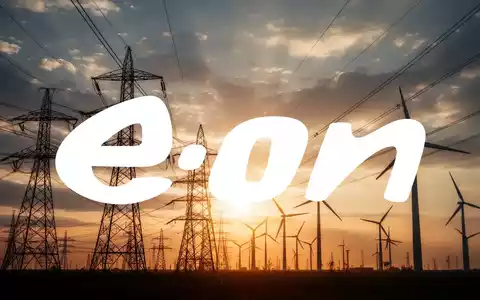 Silhouetten von Hochspannungsleitungen und Windturbinen vor einem dramatischen Himmel mit warmem Licht, das Investitionen in Energienetze symbolisiert. - Foto: über boerse-global.de