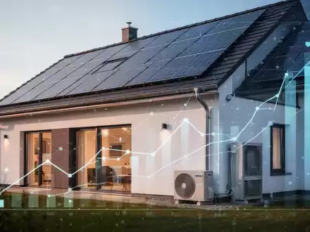 Ein modernes, energieeffizientes Haus mit Solarmodulen und Wärmepumpe, das staatliche Förderungen und finanzielle Anpassungen symbolisiert. - Foto: über boerse-global.de
