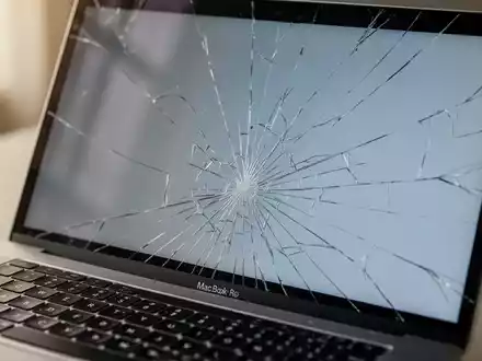 Nahaufnahme eines beschädigten MacBook-Bildschirms mit feinen Rissen, die die Auswirkung einer Tastaturabdeckung zeigen. - Foto: über boerse-global.de
