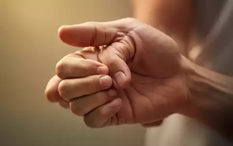 Nahaufnahme einer Hand, die sanft den Akupressurpunkt Hegu (LI4) zwischen Daumen und Zeigefinger drückt. - Foto: über boerse-global.de