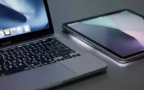 Nahaufnahme einer Apple MacBook-Tastatur und eines iPad-Bildschirms, die Apples Hardware und Dienste repräsentieren. - Foto: über boerse-global.de
