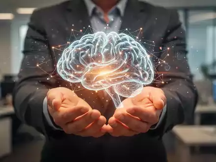 Hände halten ein leuchtendes, abstraktes digitales Gehirn in einem sanft unscharfen Büro, das psychische Gesundheit am Arbeitsplatz symbolisiert. - Foto: über boerse-global.de