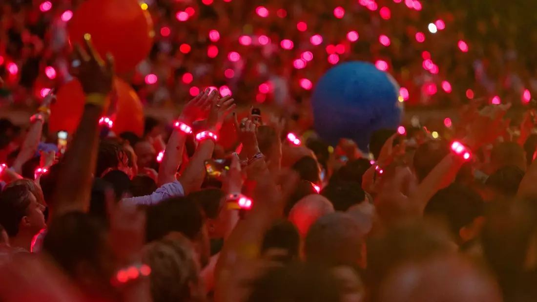 Zuschauer tragen 2024 bei einem Konzert leuchtende Armbänder, die laut Coldplay pflanzenbasiert und kompostierbar sind. (Archivbild) - Bild: Henning Kaiser/dpa