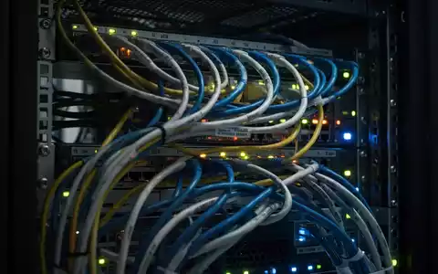 Nahaufnahme von leuchtenden Netzwerkkabeln und Serverlichtern in einem Rechenzentrumsrack, die komplexe Technologieinfrastruktur darstellen. - Foto: über boerse-global.de