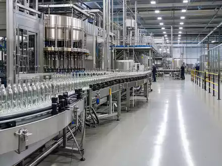 Fotorealistische Abfüllanlage der Krones AG DE0006335003 zeigt moderne Glasflaschen-Produktionslinie in hell beleuchteter Industriehalle mit Maschinen - Foto: THN