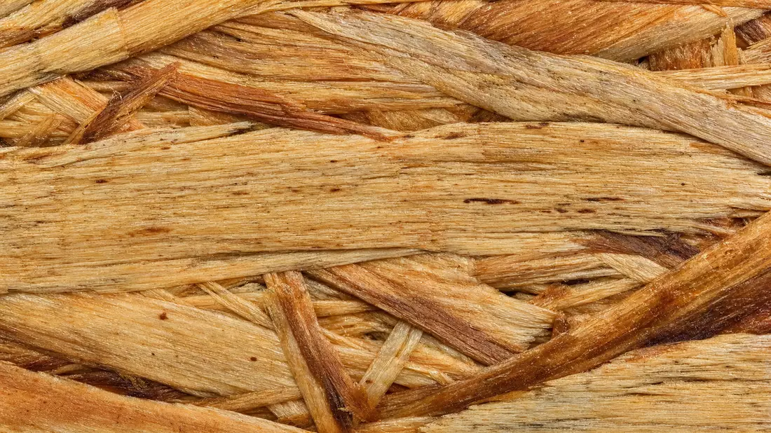 Makroaufnahme: Faserstruktur von Oriented Strand Board in Amber- und Brauntönen