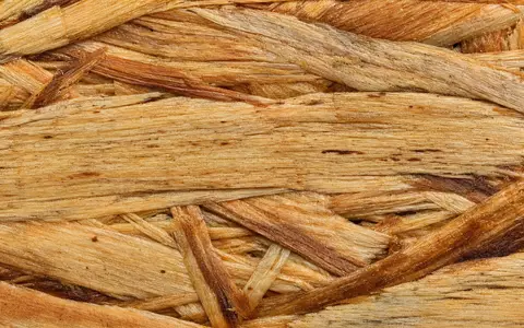 Builders FirstSource US12189T1043 extremes Makro von OSB-Holzfaserstruktur mit warmem Bernsteinlicht und Körnung - Foto: THN