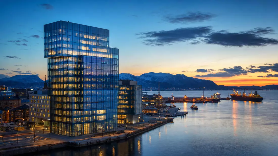 Glaserner Bankturm am Fjordhafen bei Abenddämmerung, Symbolbild Bankensektor
