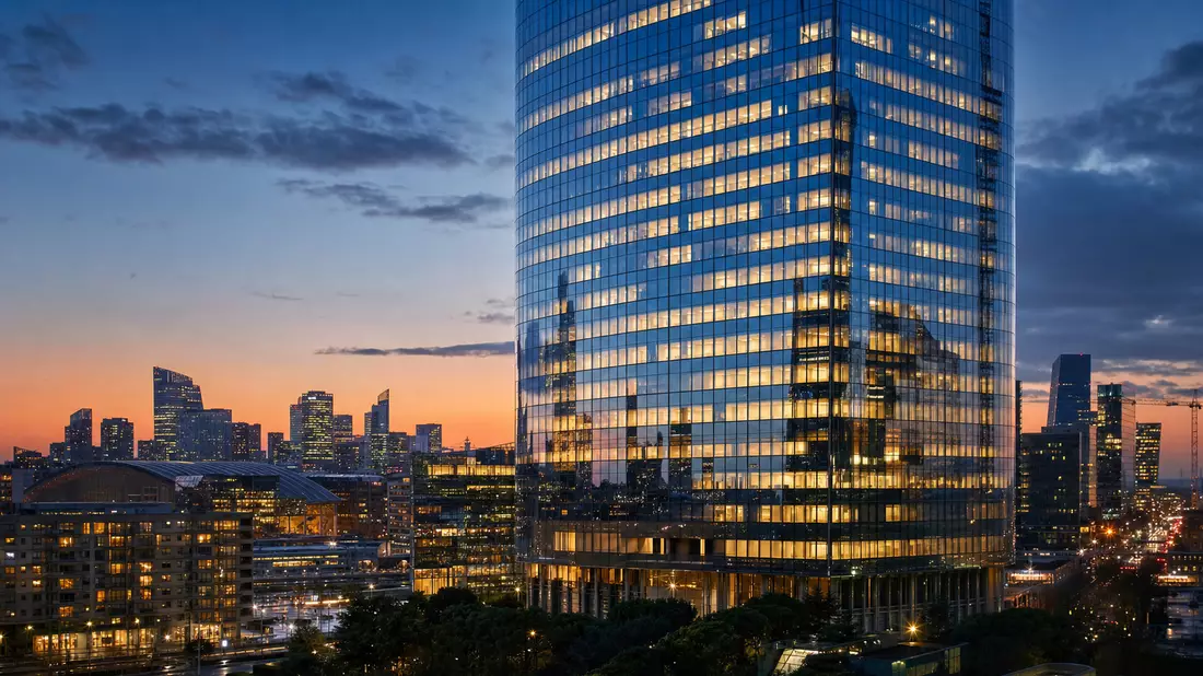 Moderne Bankfiliaden-Fassade bei Nacht, gläsernes Hochhaus, Finanzdistrikt Paris