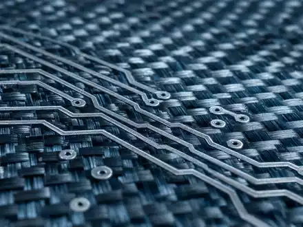 Makroaufnahme einer Karbonfaserstruktur mit Leiterbahnen veranschaulicht die Hightech-Materialien von Thales S.A. FR0000121329 - Foto: THN