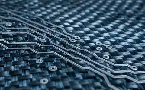 Makroaufnahme einer Karbonfaserstruktur mit Leiterbahnen veranschaulicht die Hightech-Materialien von Thales S.A. FR0000121329 - Foto: THN