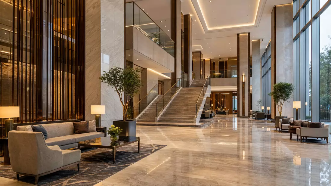 Elegante moderne Hotellobby mit Marmorboden, Treppe und warmem Licht